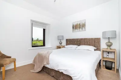 a white bedroom with a large bed and a window at 2Bedroom House - Free Parking- by Holiday Homes in Annan