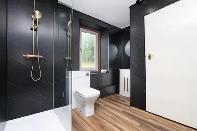 a bathroom with black walls and a toilet and a window at 2Bedroom House - Free Parking- by Holiday Homes in Annan