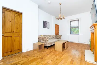 a living room with a couch and wooden floors at 2Bedroom House - Free Parking- by Holiday Homes in Annan