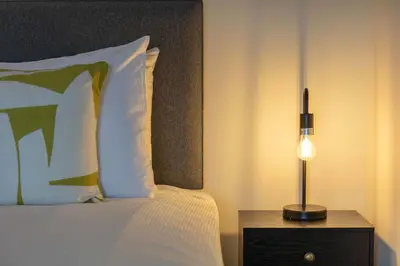 a bedroom with a bed and a lamp on a night stand at Weaver Suite - Donnini Apartments in Ayr