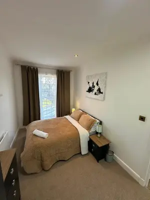 a bedroom with a large bed and a window at Fairholme Gardens House in Moffat
