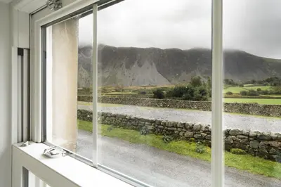 a window with a view of a river and mountains at The Screes Apartment - Short stroll from Wastwater - Herdwick Cottages