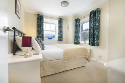 a bedroom with a bed and two windows at The Screes Apartment - Short stroll from Wastwater - Herdwick Cottages