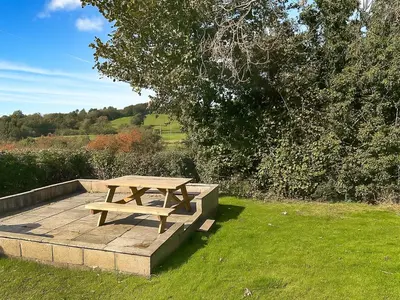 a wooden picnic table sitting on top of a field at Revita in Egremont