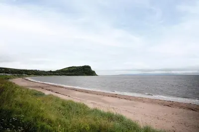a sandy beach with the ocean in the background at A&L Holiday Home Craigtara in Ayr