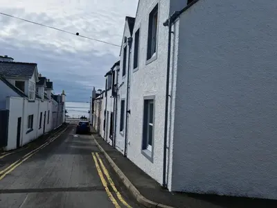 an alley with white buildings on a street at The Attic Portpatrick in Portpatrick