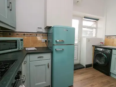 a kitchen with a blue refrigerator and a microwave at Cosy Cottage in Cumbria, West of Lake District in Broughton Moor