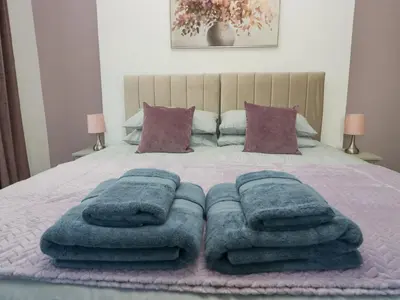 a group of towels are stacked on a bed at Cosy Cottage in Cumbria, West of Lake District in Broughton Moor