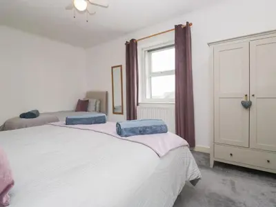 a bedroom with two beds and a window at Cosy Cottage in Cumbria, West of Lake District in Broughton Moor