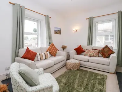 a living room with two couches and two windows at Cosy Cottage in Cumbria, West of Lake District in Broughton Moor