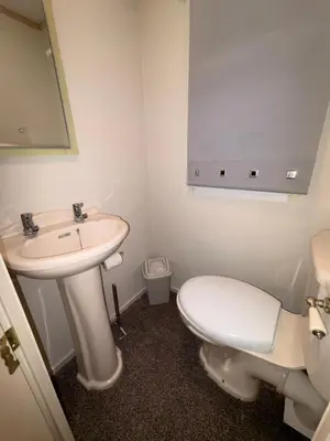 a bathroom with a white toilet and a sink at Cosy Caravan by the sea in Cairnryan