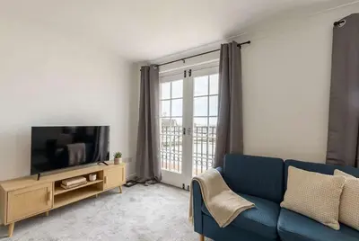 a living room with a blue couch and a tv at Fabulous 1 Bed Harbour-side Apartment with Balcony in Whitehaven