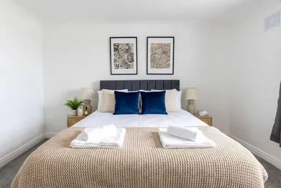 a bedroom with a large bed with blue pillows at Fabulous 1 Bed Harbour-side Apartment with Balcony in Whitehaven