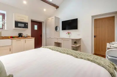 a bedroom with a white bed and a kitchen at 1 Bed in Wetheral oc-g32934 in Wreay