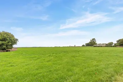 a large field of green grass with a blue sky at 4 Bed in Ellonby oc-y33284 in Ellonby