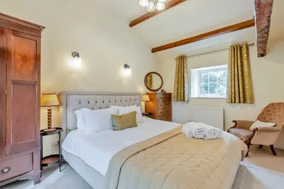 a bedroom with a large white bed and a chair at 4 Bed in Ellonby oc-y33284 in Ellonby