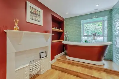 a bathtub in a bathroom with red walls at 4 Bed in Ellonby oc-y33284 in Ellonby