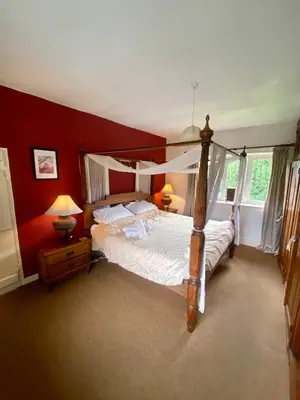 a bedroom with a canopy bed and red walls at School House in Patterdale