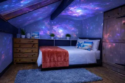 a bedroom with a bed with a starry ceiling at Old Post Office By The Sea in Allonby