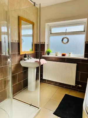 a bathroom with a sink and a shower at Old Post Office By The Sea in Allonby