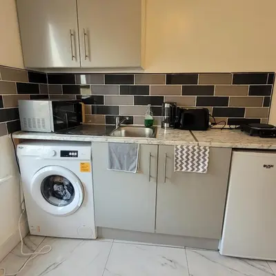 a kitchen with a washing machine and a sink at 3 Bedroom house Abbey wood London in Moffat