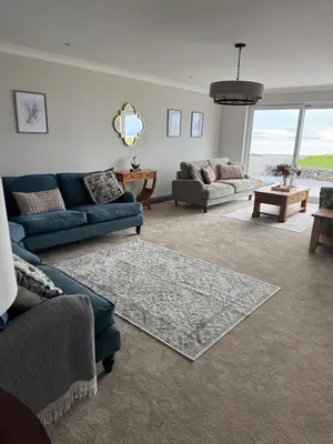 a living room with blue couches and a table at Rumblekirn in Annan