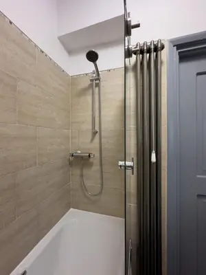 a bathroom with a shower with a tub at Coastal Lakes Mews Cottage