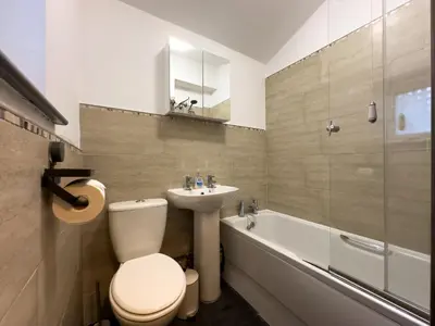 a bathroom with a toilet and a sink and a bath tub at Coastal Lakes Mews Cottage