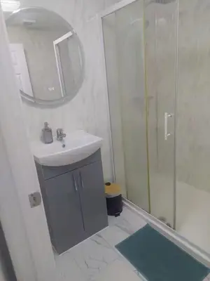 a white bathroom with a sink and a shower at Favourland Home in Moffat