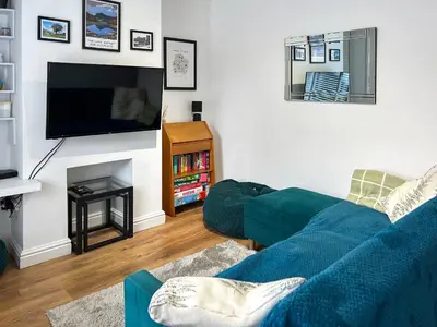 a living room with a blue couch and a tv at Miner's Rest in Frizington