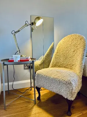 a chair sitting next to a table with a lamp at Central London Designer Room with Balcony Elevator in Moffat
