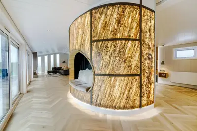 a living room with a wooden wall with a fireplace at Landal North Lakes