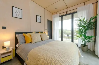 a bedroom with a bed and a large window at Landal Barnsoul in Shawhead