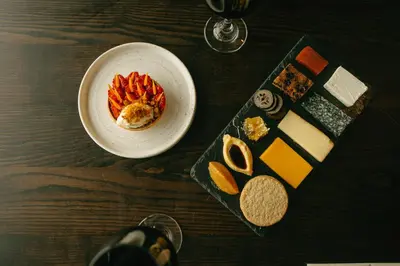 a table topped with a plate of food and cheese at Landal Whitbarrow in Penruddock