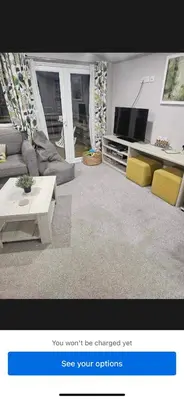 a living room with a couch and a tv at Loch View 30 in Stranraer