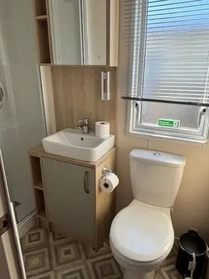 a bathroom with a white toilet and a sink at Deblisa in Longtown
