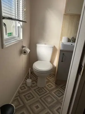 a small bathroom with a toilet and a sink at Deblisa in Longtown