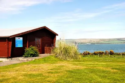 a small cabin with a view of the water at Loch View 28 in Stranraer