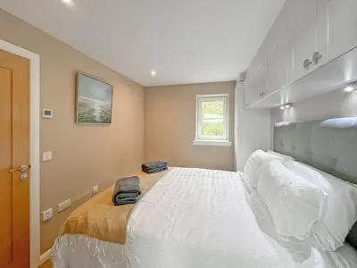 a bedroom with a large white bed in it at Grey Rocks Apartment in Kippford