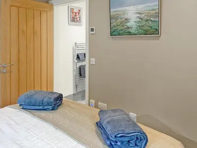 a bedroom with a bed with two pillows on it at Grey Rocks Apartment in Kippford