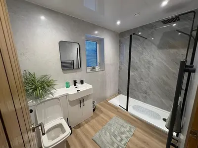 a bathroom with a shower and a toilet and a sink at Woodway Lodge in Dumfries