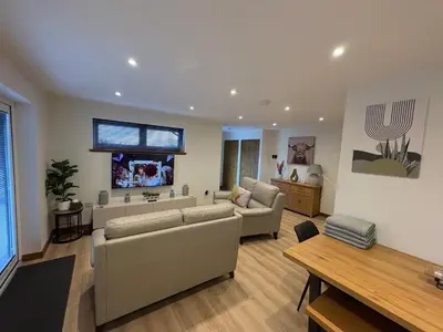 a large living room with couches and a table at Woodway Lodge in Dumfries