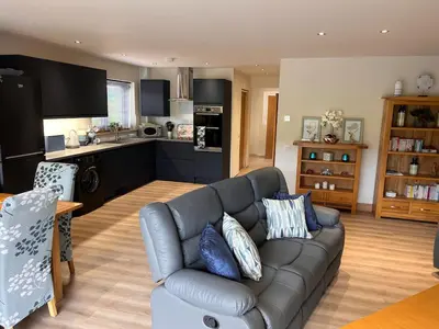 a living room with a couch and a kitchen at Woodlane 3bedroom7 seater hottub and a pool table in Beeswing