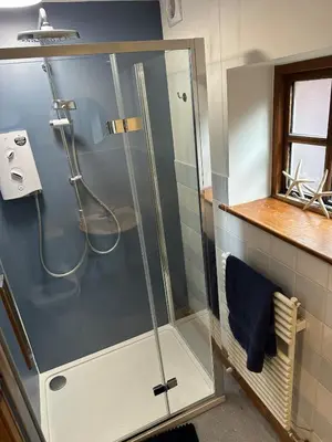 a shower with a glass door in a bathroom at The Dairy in Moffat