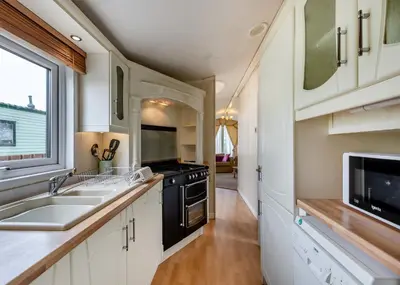 a kitchen with a sink and a stove at Rowanbank Caravan Park in Beckfoot