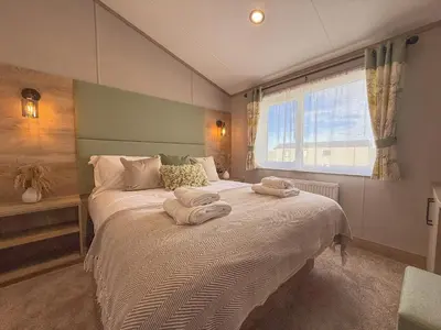 a bedroom with a large bed with towels on it at Hornbeam Lodge in Bassenthwaite