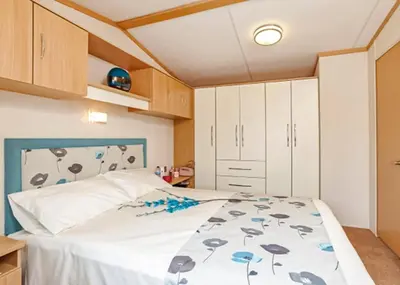 a bedroom with a bed in a room with cabinets at Stanwix Park in Silloth