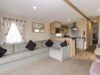 a living room with a couch and a kitchen at Peaceful in Stranraer