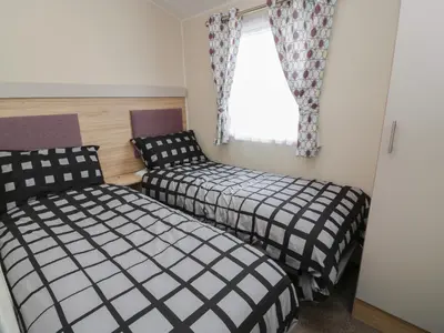 a bedroom with two beds and a window at Peaceful in Stranraer