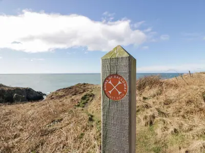 a sign with a clock on the side of a beach at Peaceful in Stranraer
